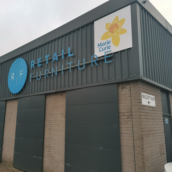 Marie Curie sign beside Retail Furniture company logo